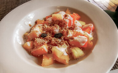 Fruit on plate for breakfast melon apple papaya pineapple mango banana.