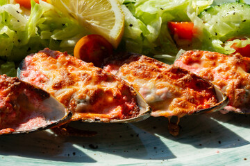 baked mussels with masago caviar and cheese on a white plate