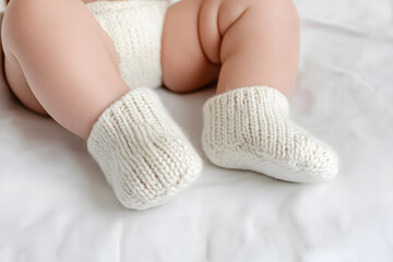 Detailed View of Baby Legs Wearing Cozy Knitted Slippers, Adorable and Comfortable Infant Footwear
