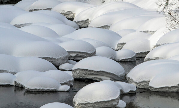 Snow-covered rocks in a riverbed, Niseko, Japan