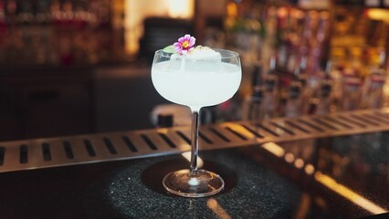 Closeup mixed creamy vodka cocktail glass decorated flower preparation, making special drink menu to VIP guest at front bar luxury. Special refresh drink showcasing nightlife at nightclub. Vinosity.