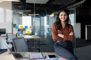 Portrait of young beautiful Latin American business woman, company employee smiling and looking at...