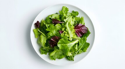 Fresh mixed salad greens on a plate isolated on white background