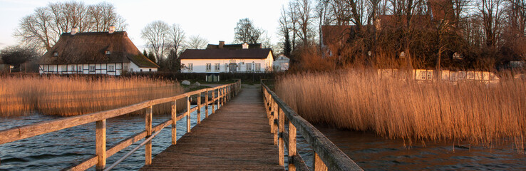 Obraz premium Idyllisches Dorf Sieseby an der Schlei mit Steg und Fährhaus.