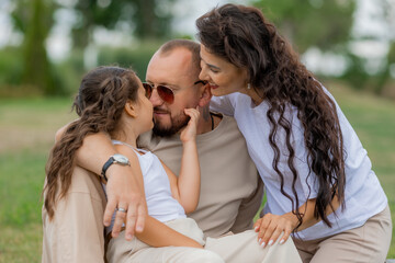 Fototapeta premium happy family is relaxing on a green lawn in the park in summer