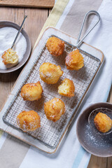 Curd donuts with sugar served with tea or coffee on a light wooden background. Rustic style.