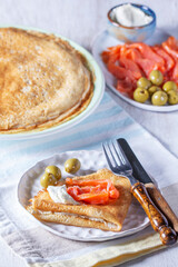 Pancakes with gravlax, cottage cheese and olives. A traditional dish for Maslenitsa or Carnival.