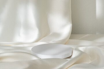 Modern Minimalist White Sculpture Displayed on Soft Draped Fabric in Natural Light