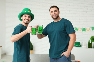 Young men with mugs of beer at home. St. Patrick's Day celebration