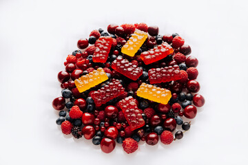 Colorful natural berry marmalade on fresh mixed fruits and berries, healthy sweet indulgence