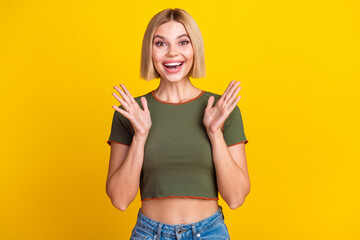 Photo of overjoyed nice girl with bob hairstyle dressed khaki t-shirt astonished staring palms up...