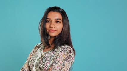 Portrait of optimistic indian woman wearing colorful clothes with positive facial expression smiling, looking pleased. Calm person in traditional clothing feeling satisfied, studio backdrop, camera B