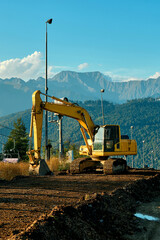 A heavy excavator is working in the mountains