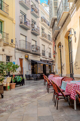 Fototapeta premium malaga old town architecture details during day hour, empty restaurant tables with no people