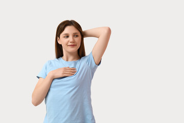 Young woman checking her breast on white background