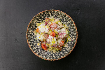 Pasta with mushrooms, cherry tomatoes, and creamy sauce topped with microgreens and Parmesan cheese