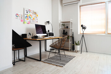 Table with modern computer, photo camera and gadgets in office. Photographer workplace concept