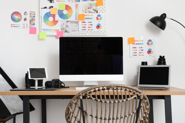 Table with modern computer, photo camera and gadgets in office. Photographer workplace concept