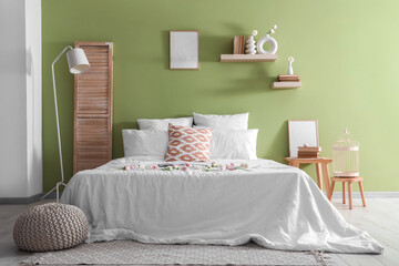 Beautiful interior of bedroom with bed, pillows and flowers