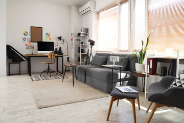 Stylish office with workplace, sofa and photographer gadgets