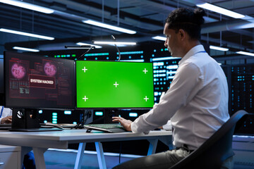 IT professional in server hub using mockup computer, trying to protect hardware from hacker....
