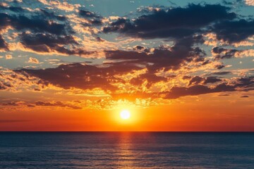 Fototapeta premium A stunning sunset over a calm ocean, with the sky painted in hues of orange, pink, and purple, while the horizon showcases a serene and tranquil seascape.