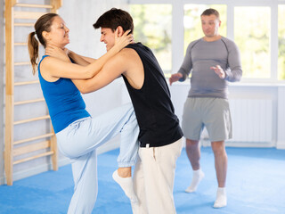 Young man and woman in sparring improve skill of performing strangulation and neutralizing enemy....