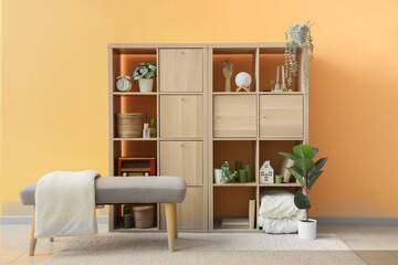 Bench and shelving unit near orange wall in room