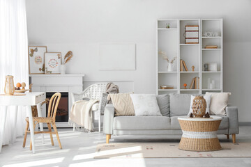 Interior of stylish living room with cozy sofa, fireplace, shelving unit and coffee table