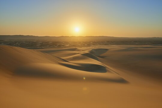 Sunset over a vast desert landscape with gentle sand dunes and clear sky, Matruh, Great Sand Sea, Libyan Desert, Sahara, Egypt, North Africa, Africa