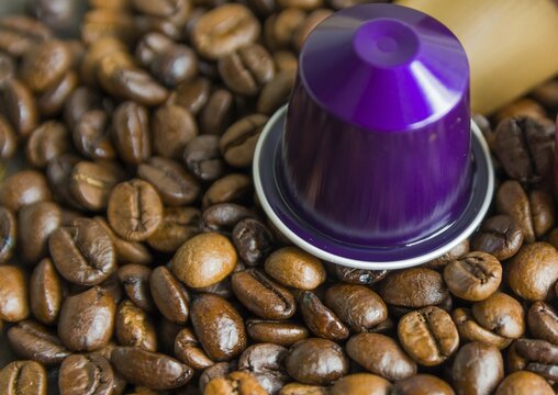 Beautiful colored coffee capsule on coffe beans background