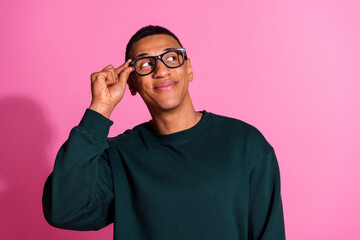 Photo of cheerful positive guy dressed pullover arm eyewear looking emtpy space isolated pink color...