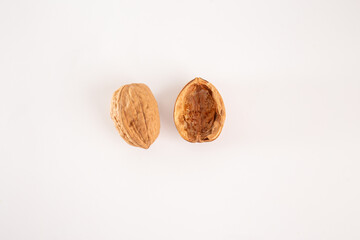 half of a walnut on a white background, one intact outer shell and one hollow inner shell with meat removed. Ideal for themes of food, nutrition, natural textures, or visual metaphors.