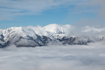 Picos de montañas nevadas con bruma