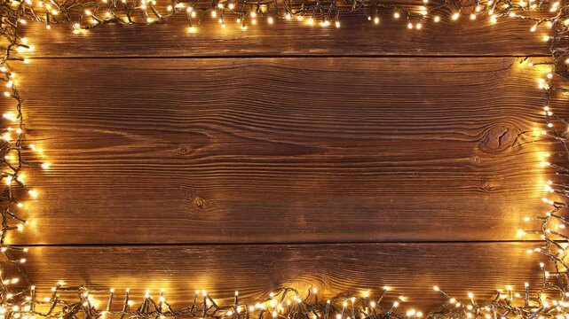 Christmas lights frame loop on rustic wooden background. Realistic garland on old wooden planks. 
