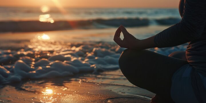 Close-up of a woman meditating on a serene beach at sunrise
