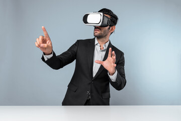 Smart manager looking at data by using VR goggle while pointing at data analysis. Caucasian investor connect metaverse while wearing suit and virtual reality headset. Innovation technology. Deviation.