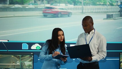 Team leaders reviewing traffic data collected from video surveillance footage, monitoring urban infrastructure by using CCTV cameras system. Government agency works on public safety. Camera B.