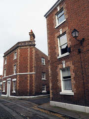 street of old traditional red brick Georgian houses on a cobbled road in Chester England