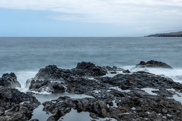 Photograph silky water long exposure on rocks in the middle of the sea. Concept: Water, silky water, sea, maritime.