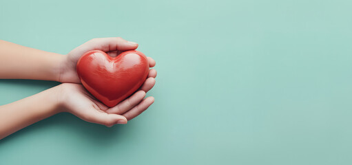 A red heart ball in my hand against a green background