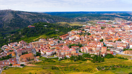 Obraz premium Aerial view of small Spanish city of Soria on background of picturesque landscape with river and green hills ..