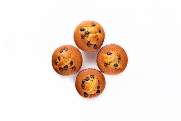 Obraz premium Four delicious, freshly baked muffins with chocolate chips on top. Overhead shot on white background.