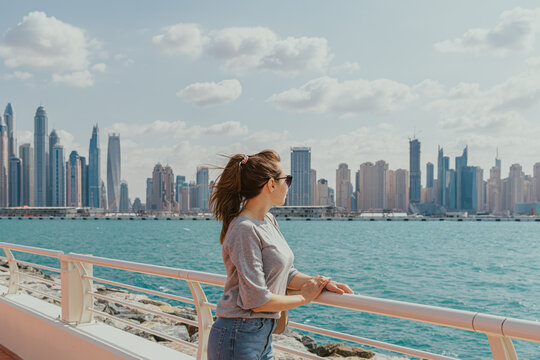 Woman overlooking the city skyline from a waterfront walkway