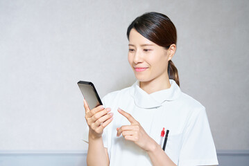 Fototapeta premium スマートフォンを操作するユニフォーム姿の女性