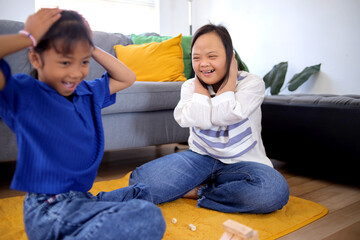 Two Asian Little Girls Playing Wooden Blocks Tower And Surprised When The Tower Falling Down