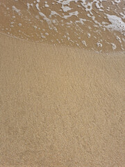 
It is a sandy beach with waves rolling in.