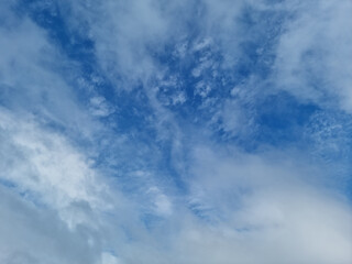 It's a blue sky with atmospheric puffy clouds.