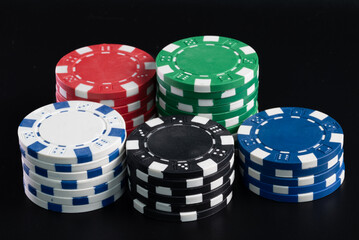 Poker chips of all the classic colors stacked by colors 