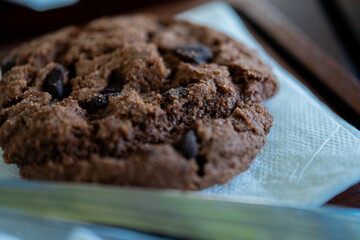 A close-up macro shot of a freshly baked, decadent double chocolate chip cookie. This cozy and...